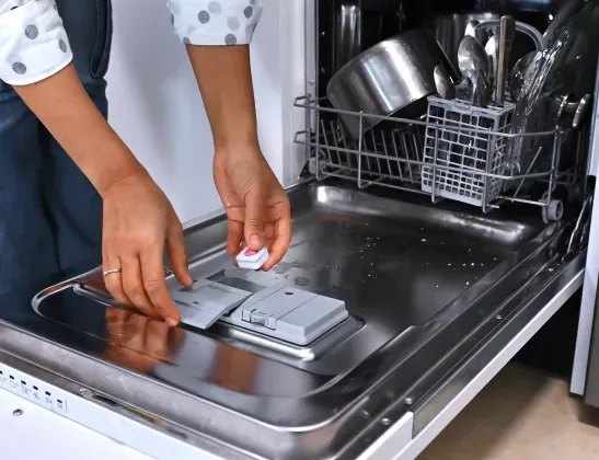 woman-adding-dishwasher-detergent-tablet-to dishwasher